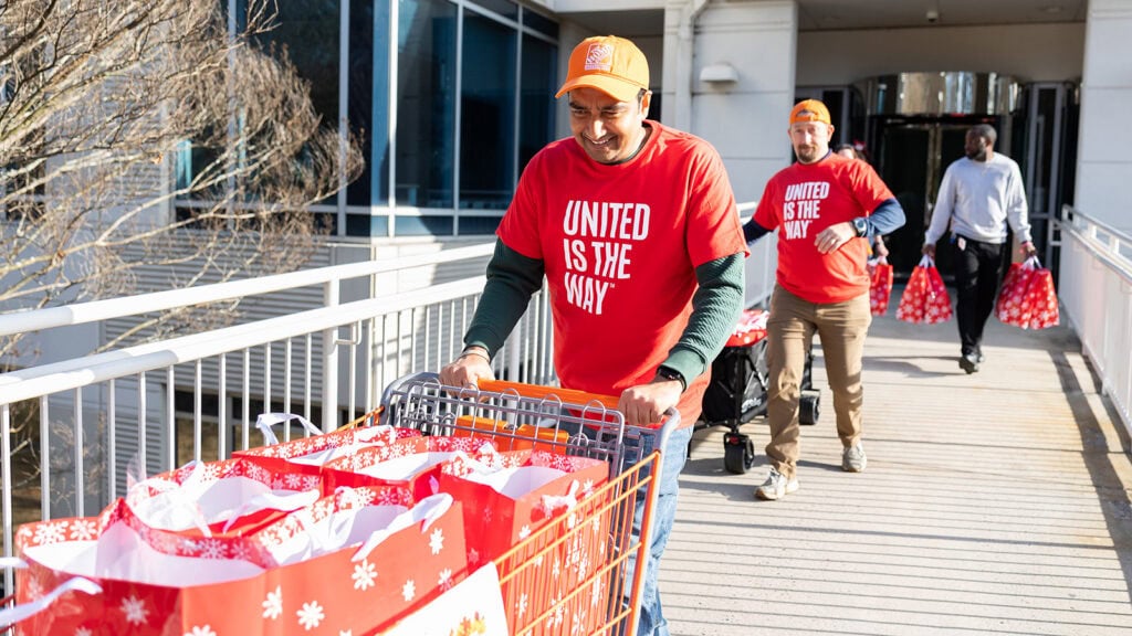 A volunteer pushes a cart full of presents at a United Way of Greater Atlanta and Home Depot partnership event.