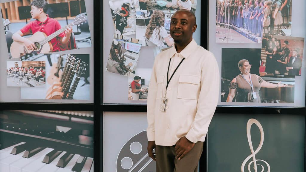 School mental health support worker stands by a mural of the students he serves