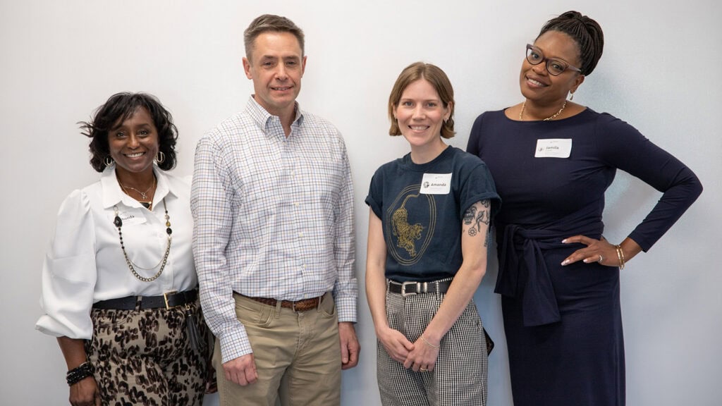 Four volunteer financial mentors prepare to teach at a financial literacy program to young professionals about wealth building and investments.